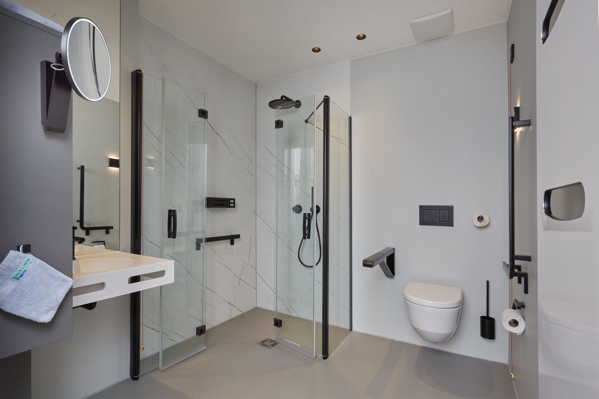 Black fittings in shower and WC with black accessories in the room at RWTH Aachen-Franziskus