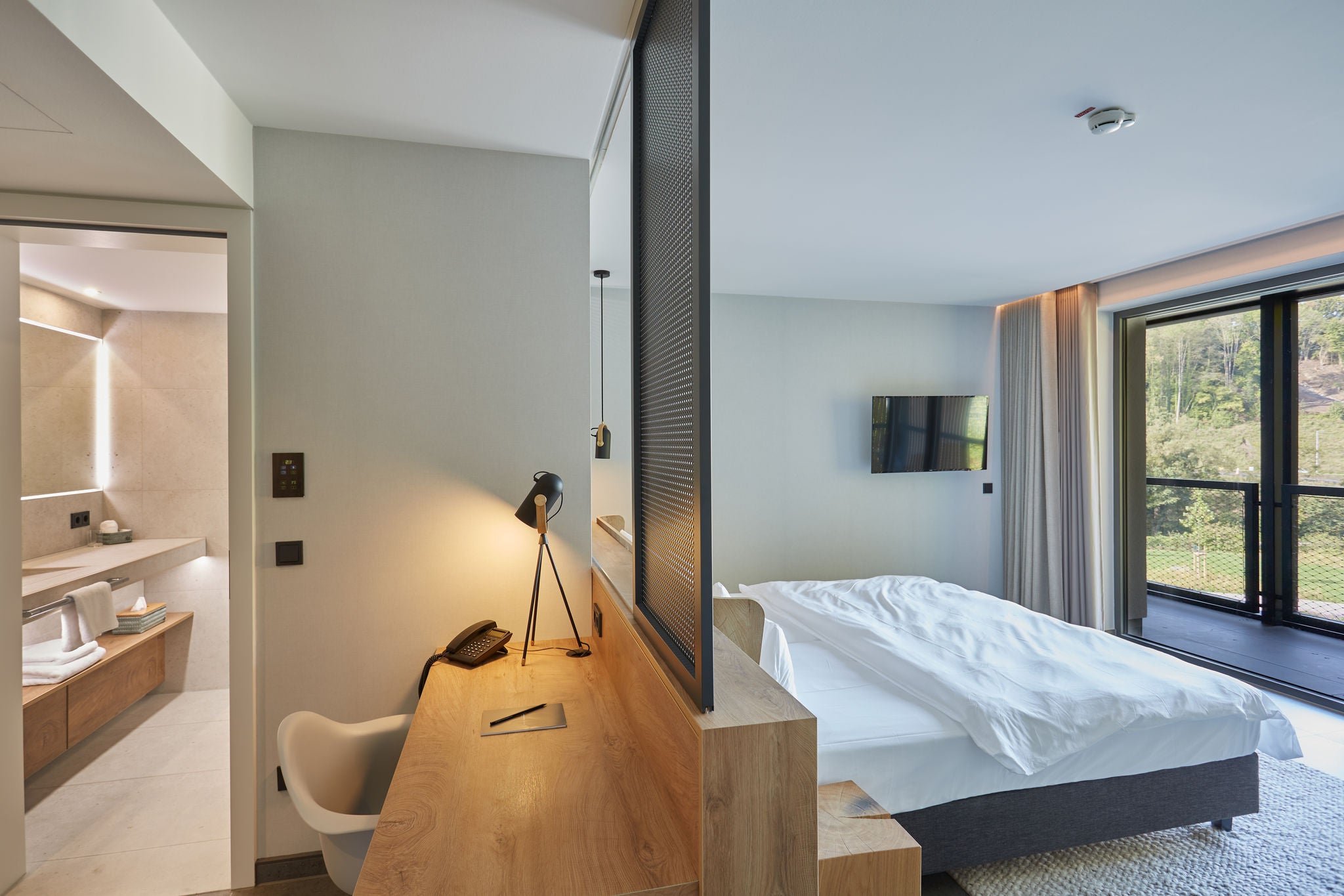Bedroom and view of the washroom with COLLECTION PLAN towel rail in the VierJahreszeiten suite in Iserlohn