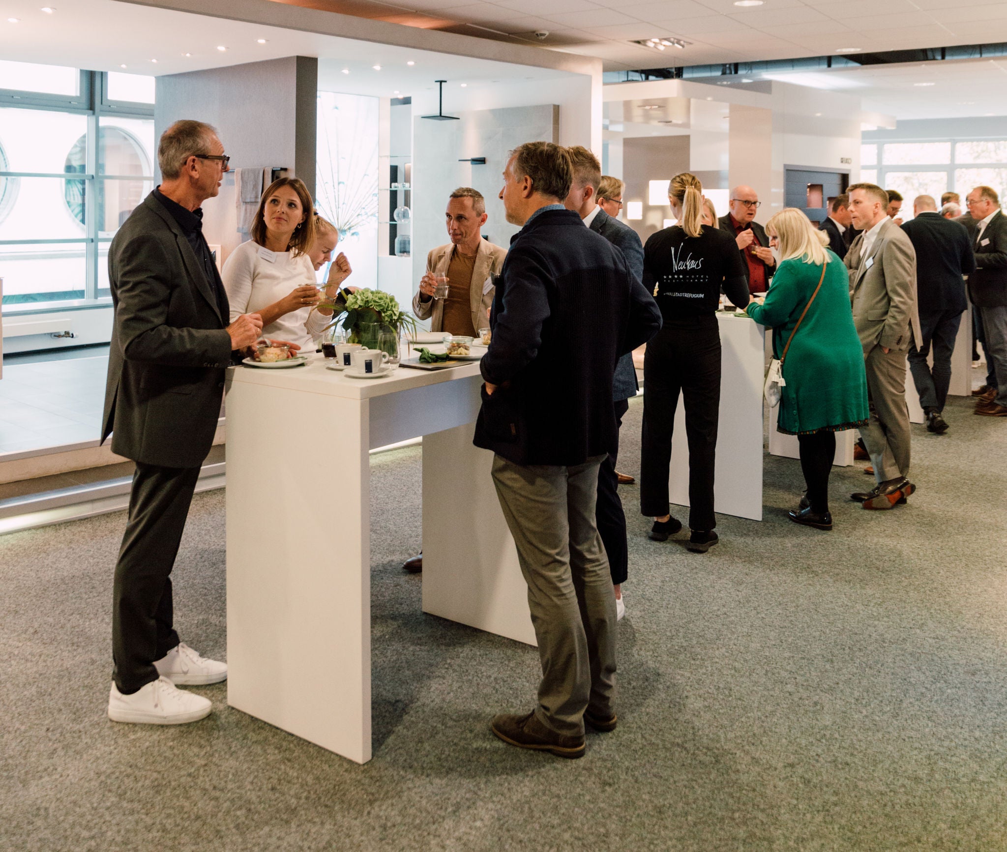 Teilnehmer im Gespräch an Stehtischen