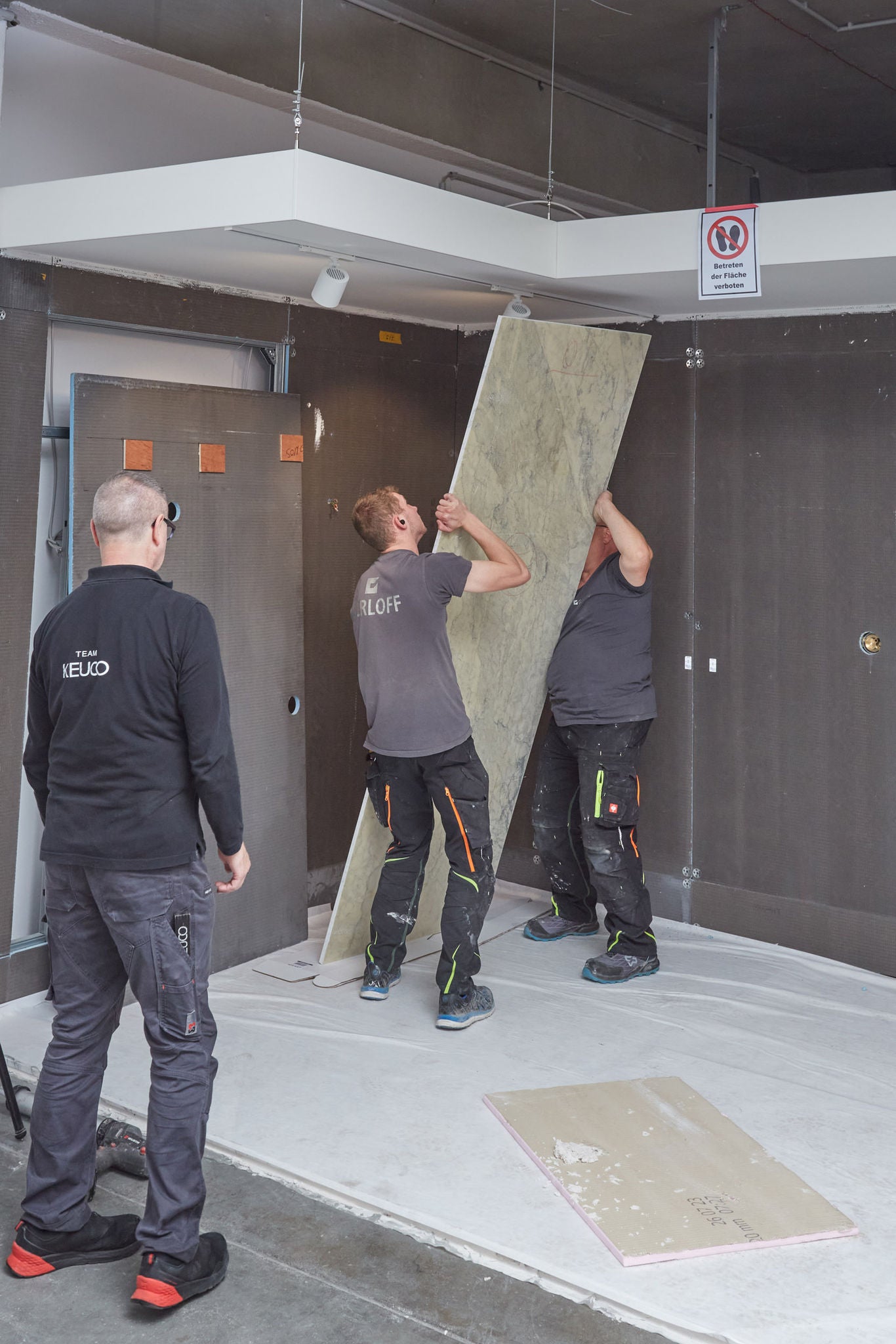 Mitarbeiter der Firma Gerloff montieren Marmoroberflächen an Böden und Wänden