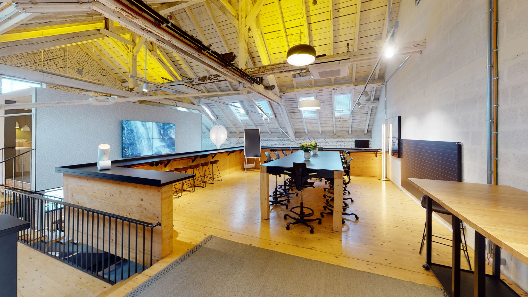 Meetingraum in einem Dachgeschoss mit schwarzen Möbeln und einem Flipchart