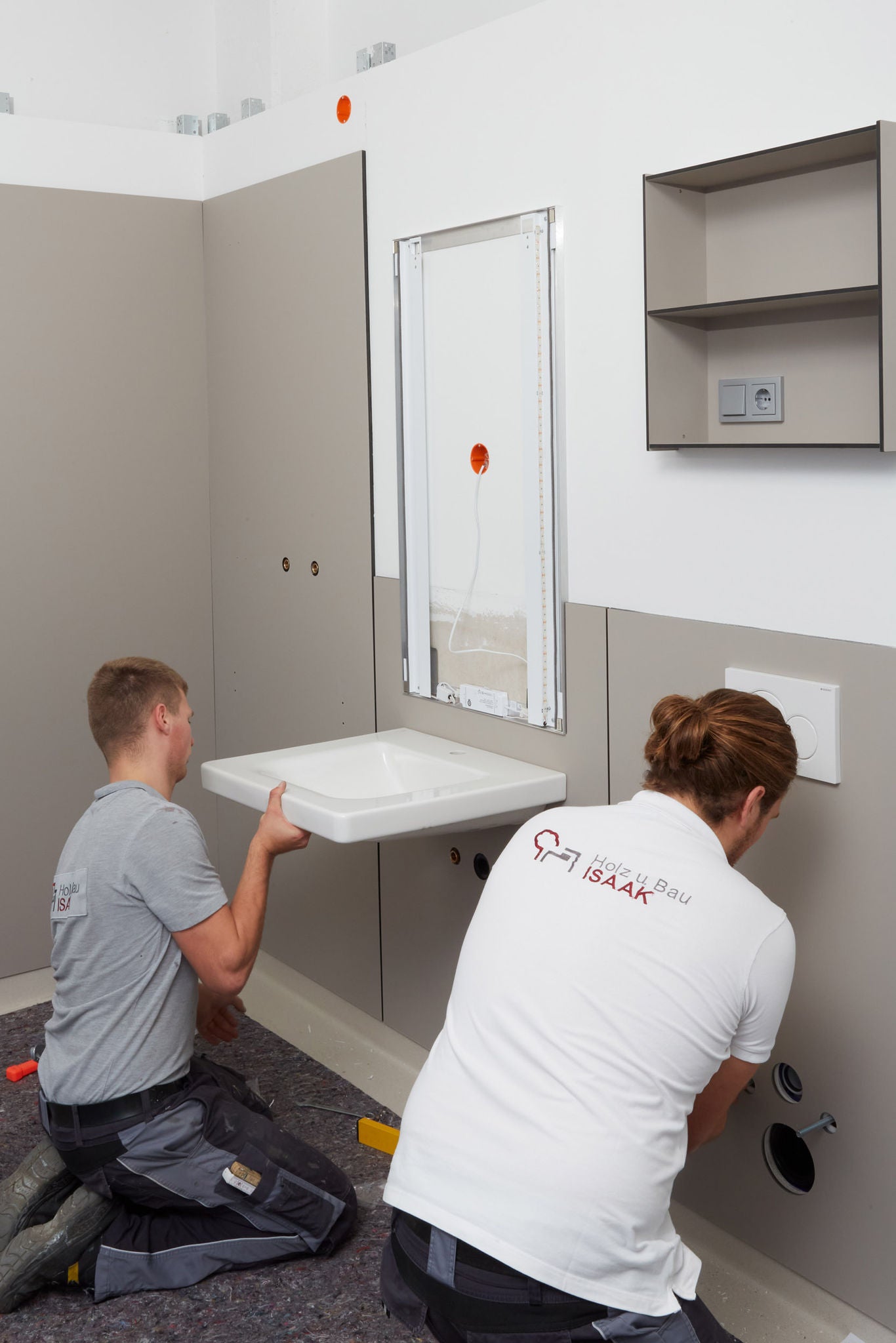 Handwerker montieren einen Waschtisch in einer systemischen Badlösung