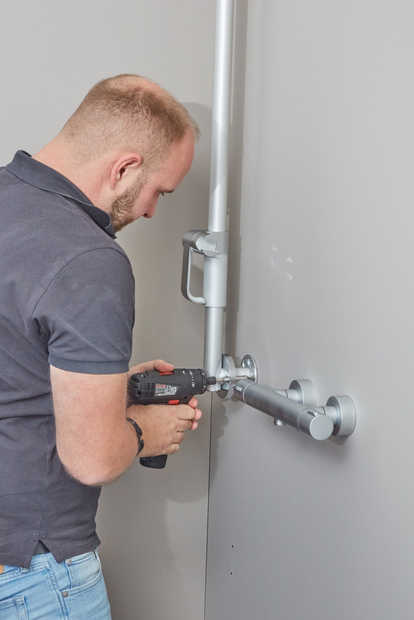 Handwerker installiert eine Duschstange im systemischen Bad