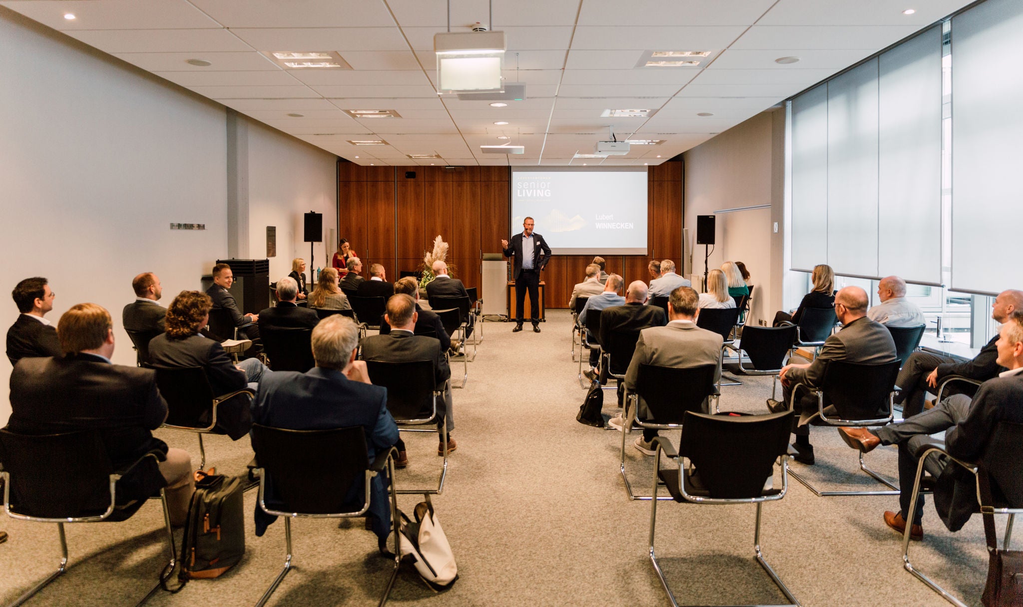 KEUCO Geschäftsführer Lubert Winnecken steht vor Publikum auf dem Expertenforum Senior Living